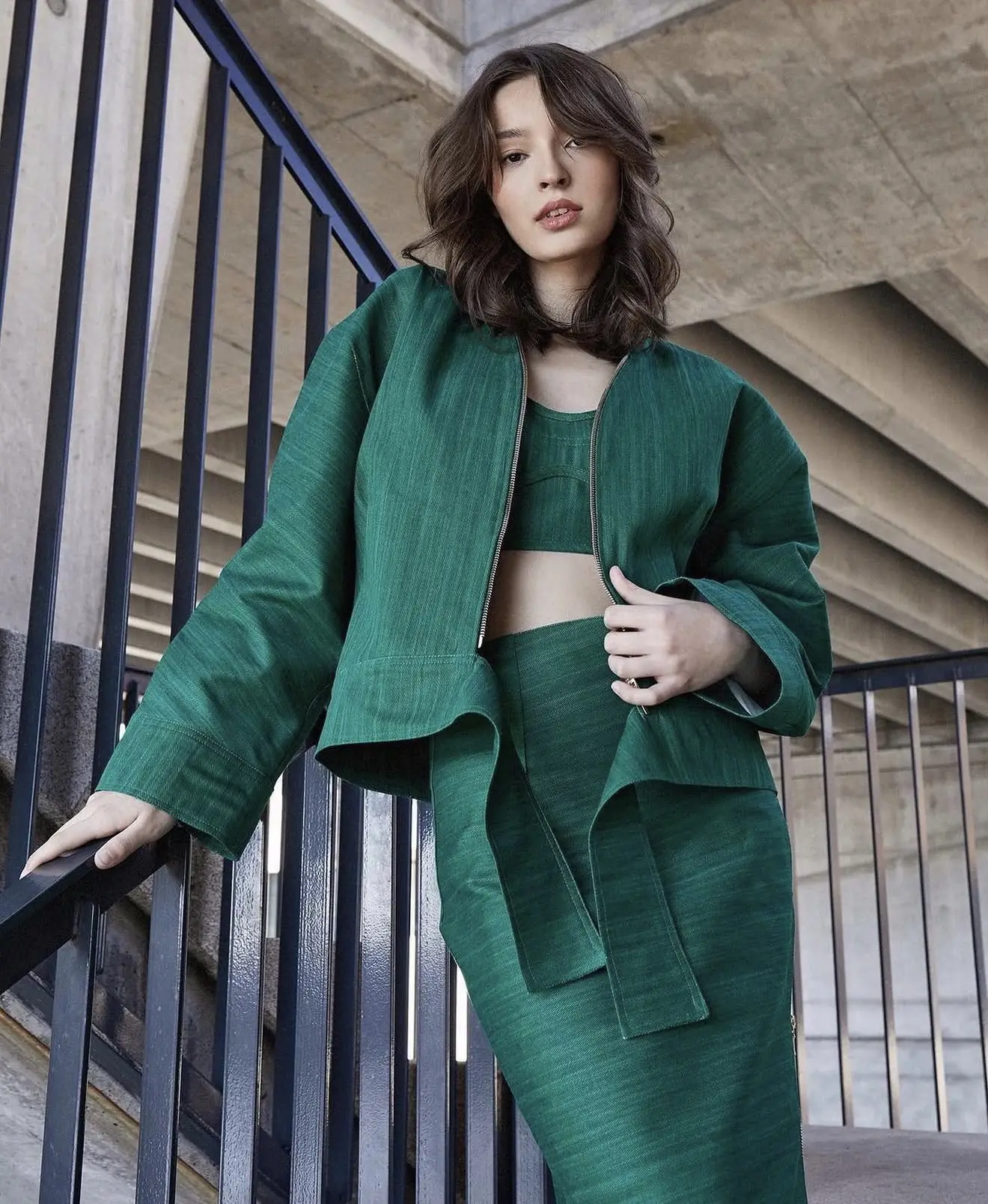 Klientka v zelenom kostýmovom sete na schodisku, osobný styling od Jankity